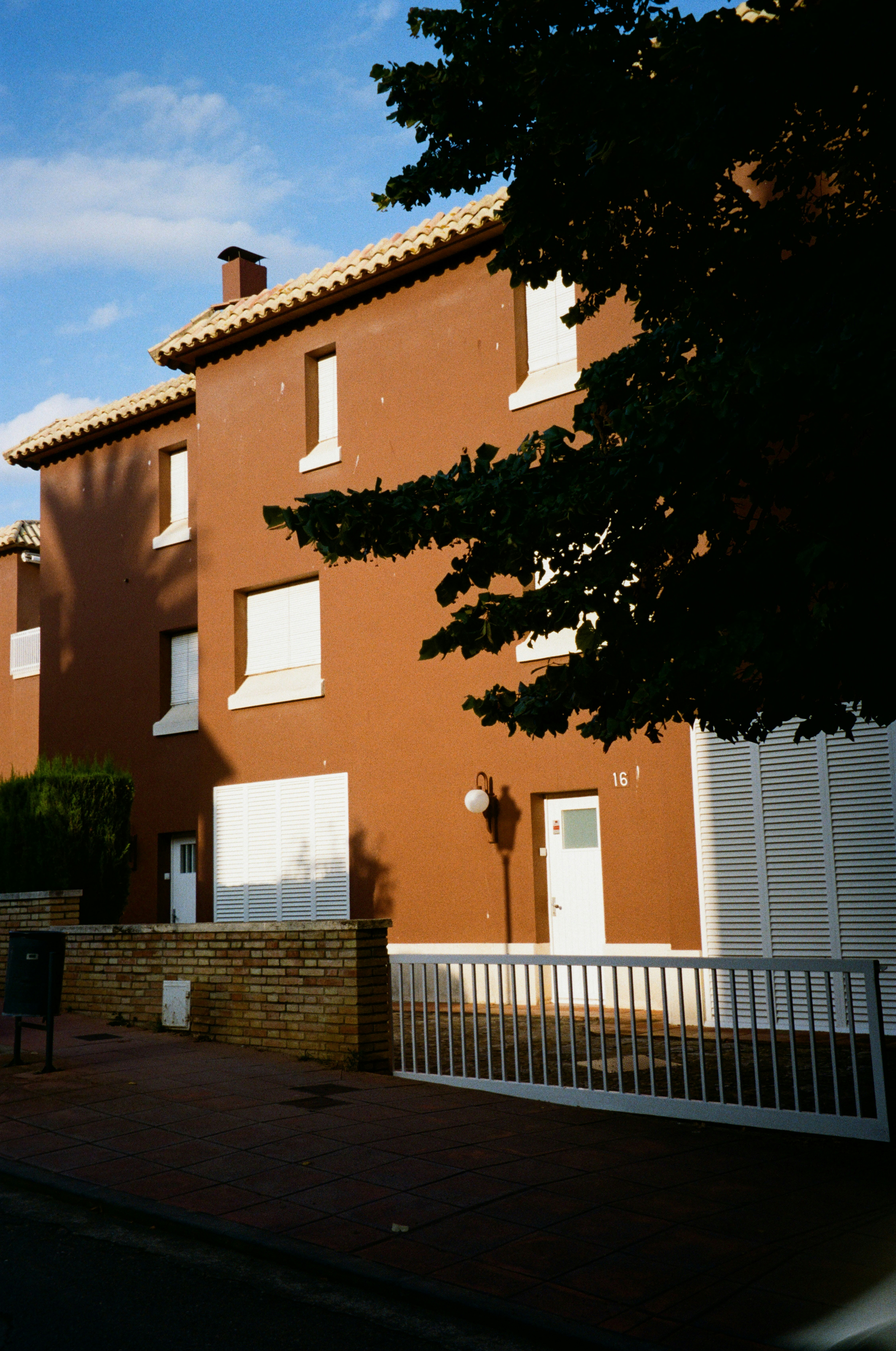 Brown building with white shutters and doors.