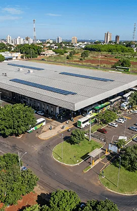 Ponto de embarque em Foz do Iguaçu com estrutura coberta, área de espera e entorno urbano visível