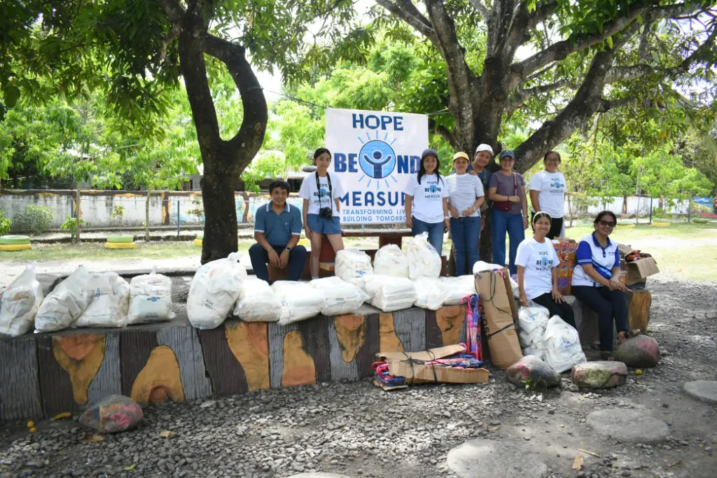 Hope Beyond Measure representatives standing with prepared support bags during an outreach event.