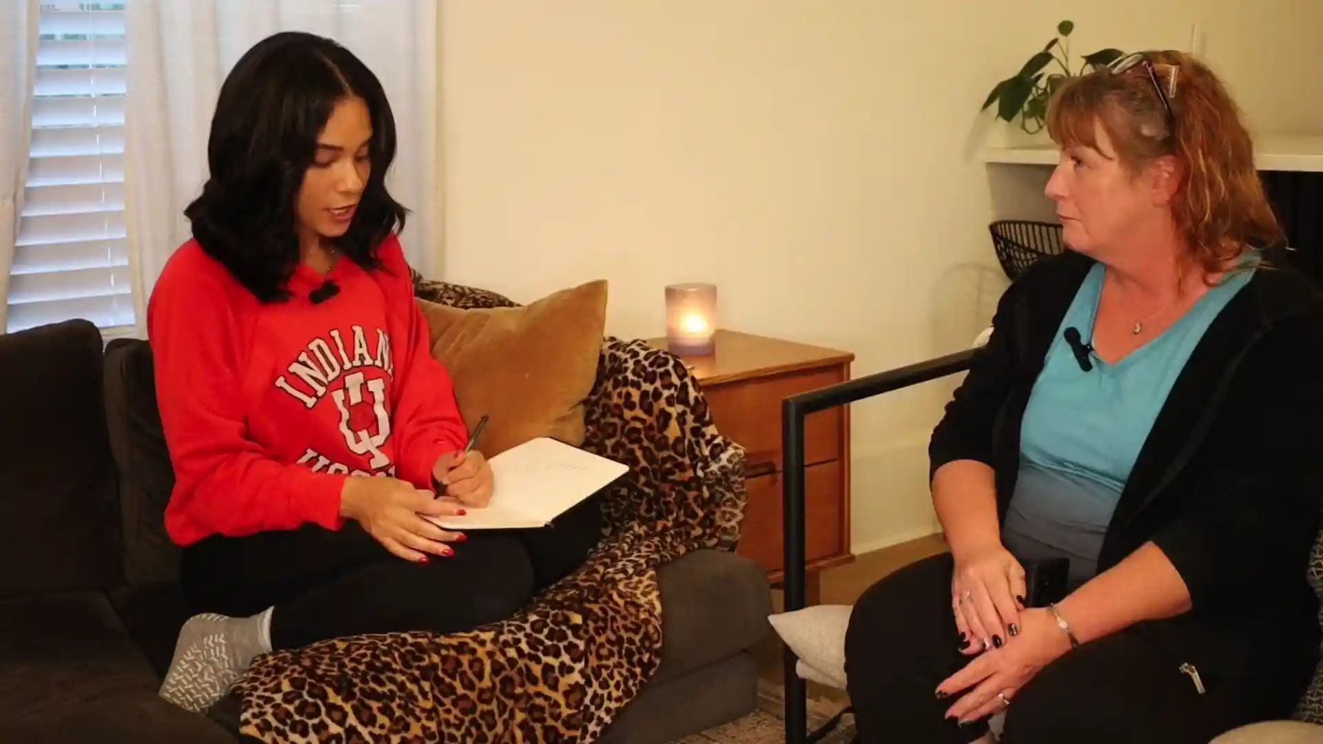 Alejandra conducting a recorded reading with a client on a sofa