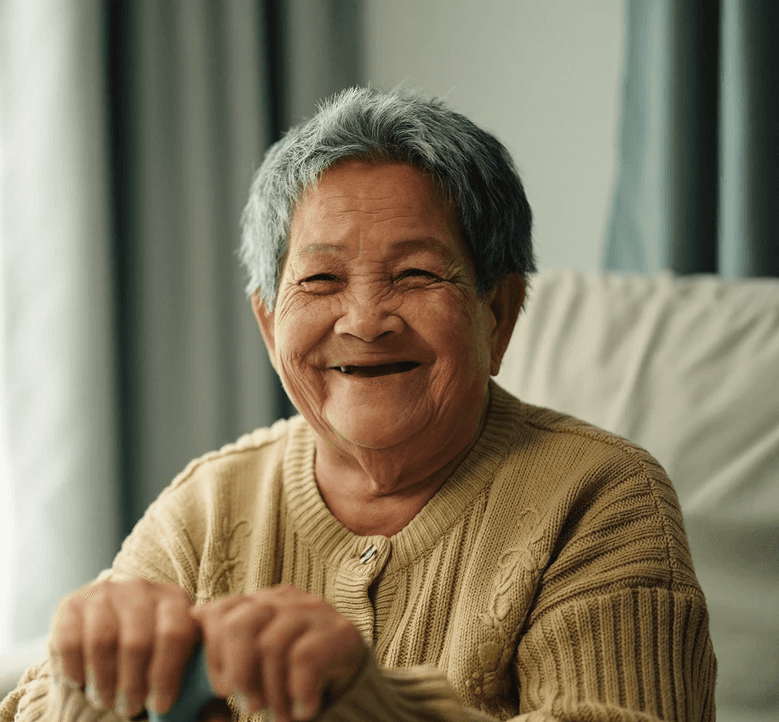 A smiling doctor with glasses and stethoscope stands arms crossed.