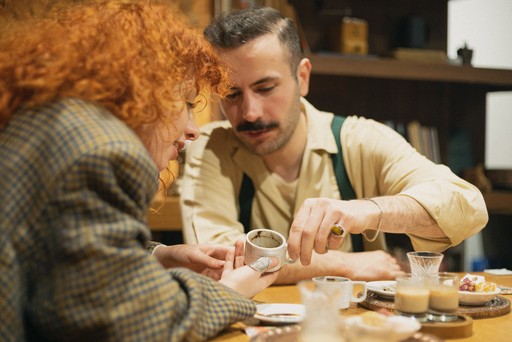 A man and a woman engaging in the Turkish coffee-making process together, capturing a collaborative and cultural experience in an Istanbul workshop.