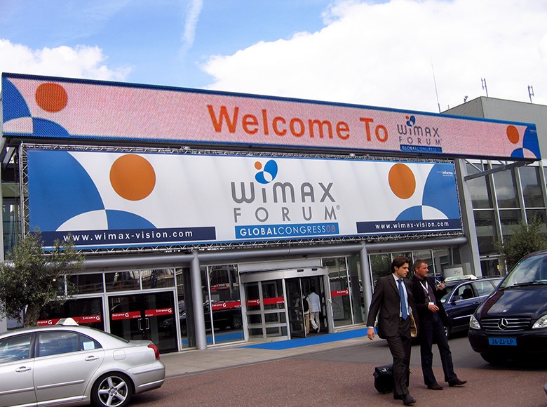 Exterior printed and digital signage at a Wimax forum event.