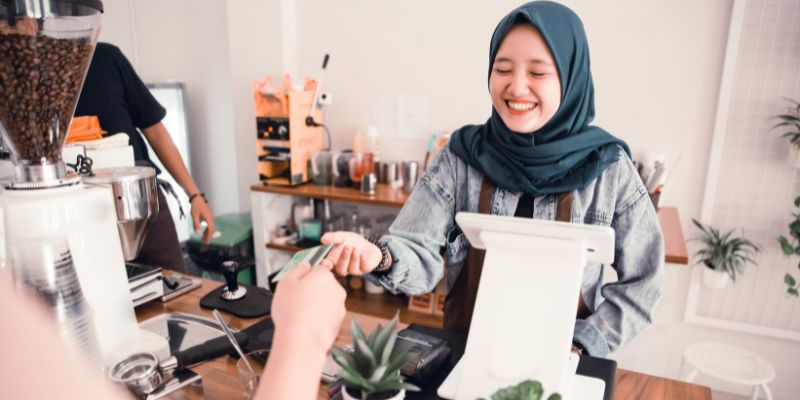 A Malaysian F&B staff happily serving a customer