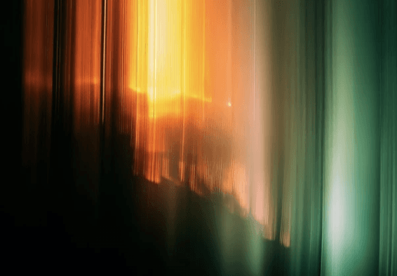 Two men discuss a project while standing at a laptop in an office.