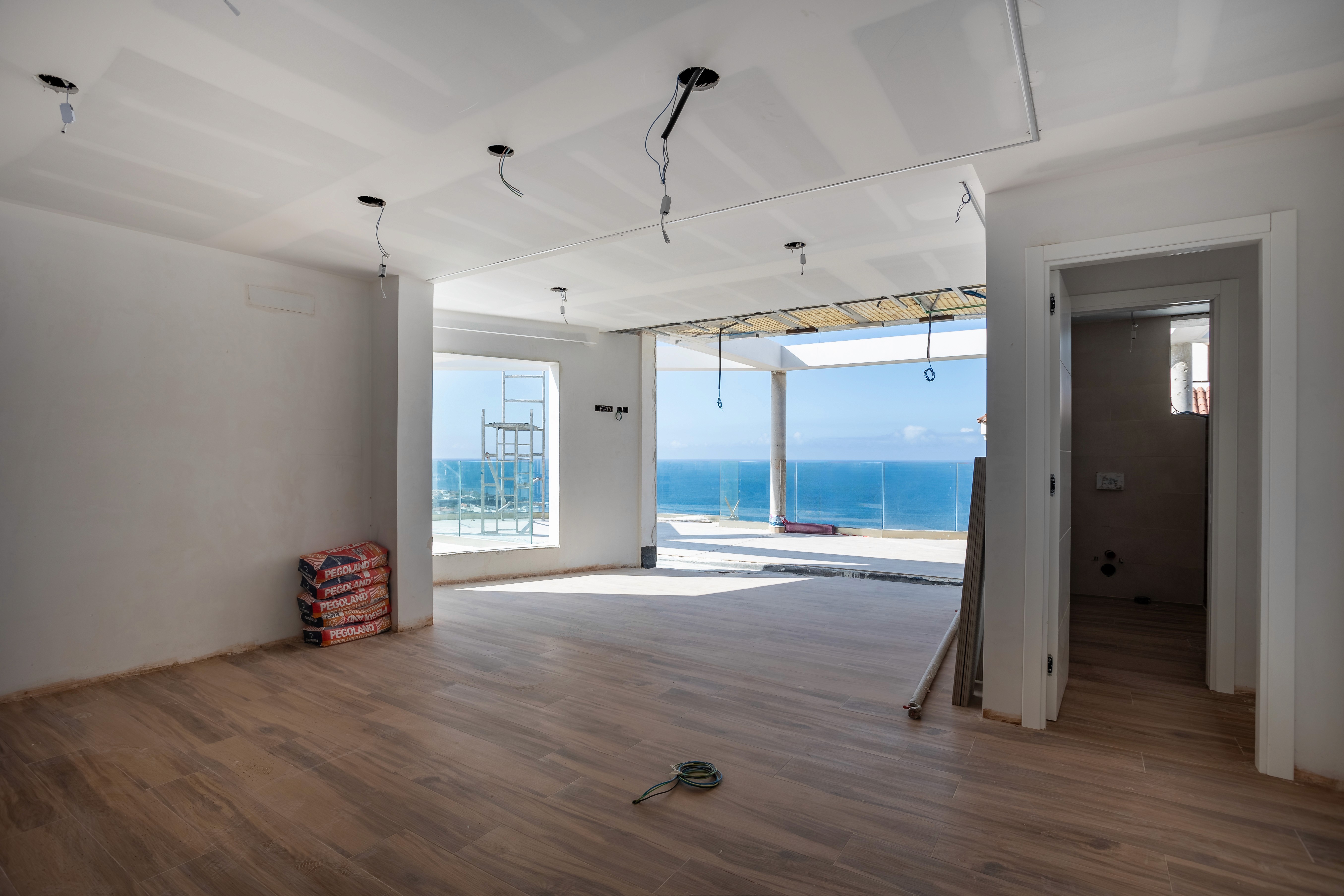 Woman in a blue shirt poses confidently with folded arms, wearing glasses and jewelry. Neon lighting casts a purple and pink glow, creating a vibrant mood.