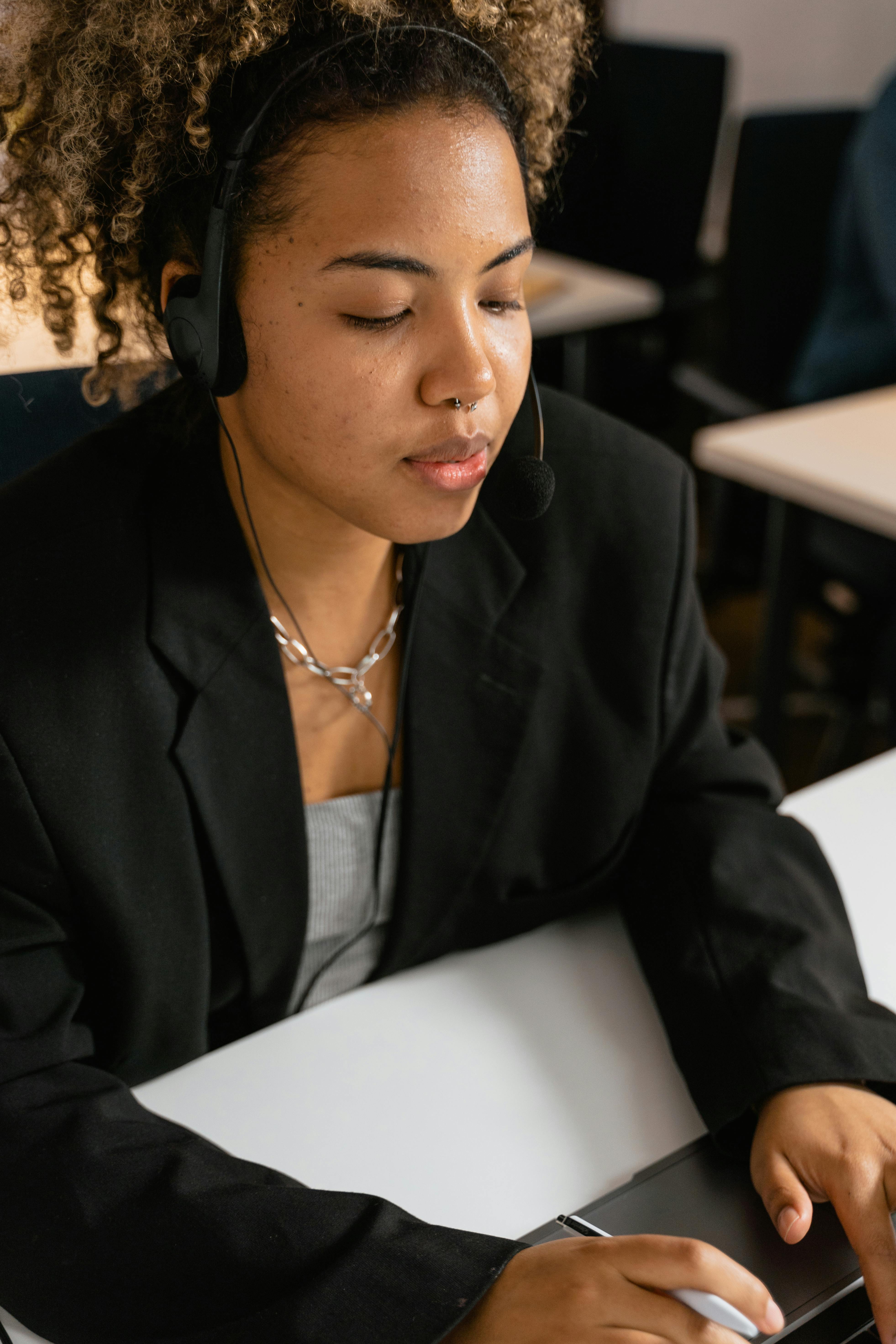 Man and woman standing together at a desk with a laptop and notebooks, smiling at the camera.