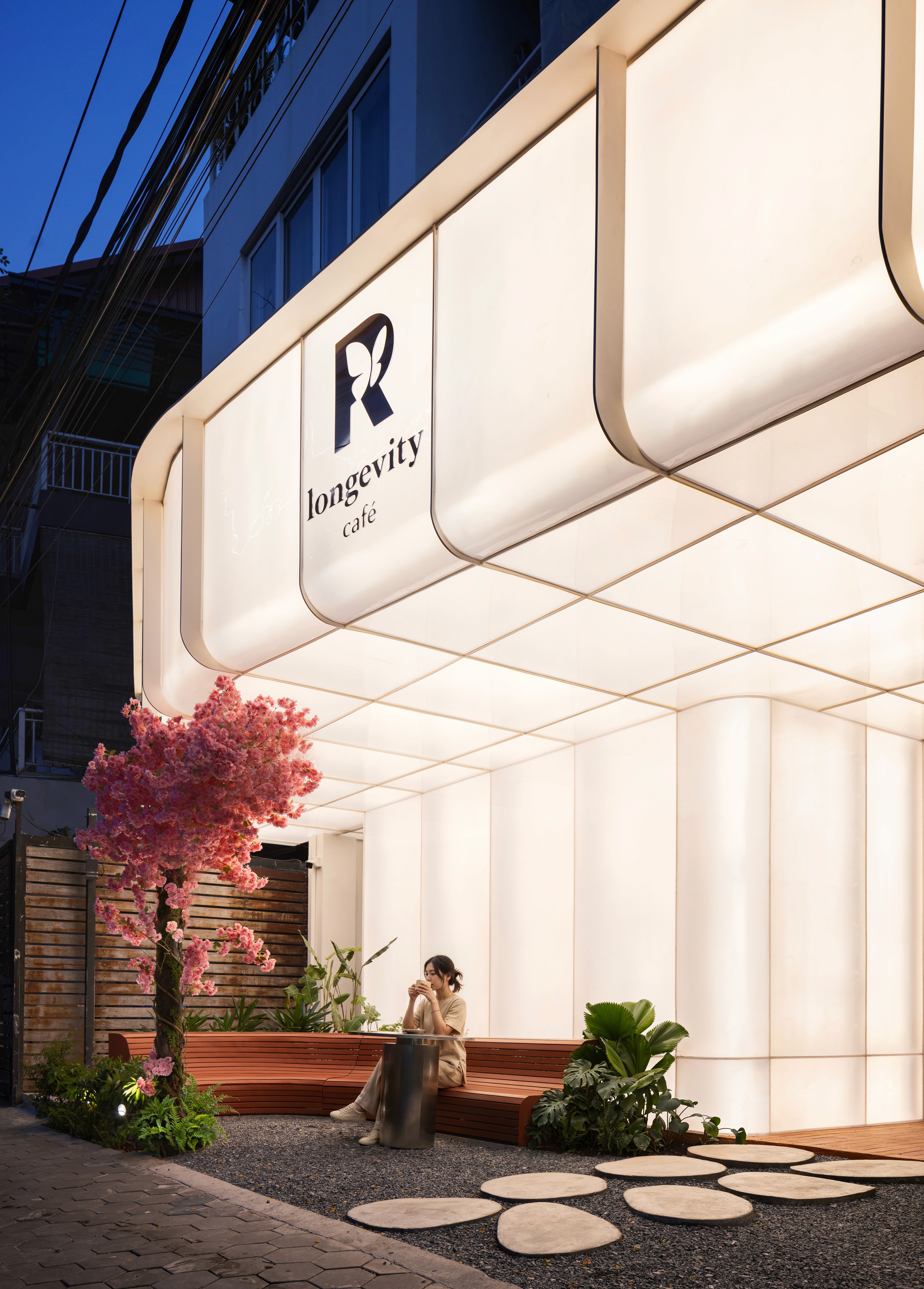 Night view of canopy and brand signage with integrated soffit lighting, consistent glow used as wayfinding and to support evening operation