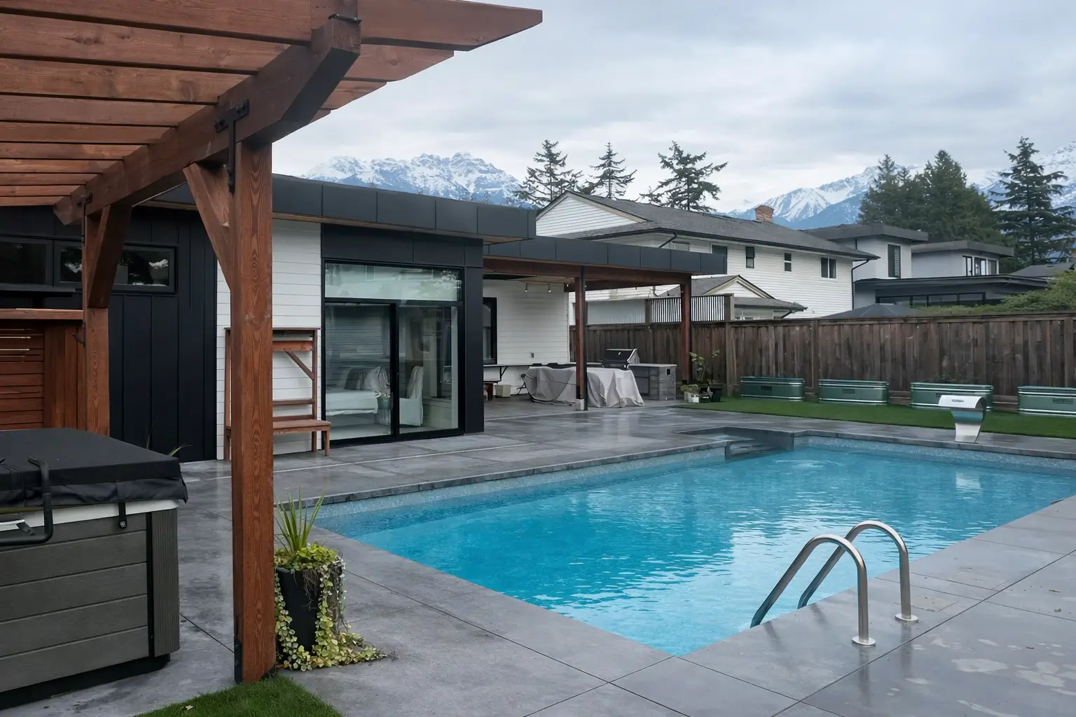 Completed backyard transformation with swimming pool, pergola lounge area, and mountain backdrop.