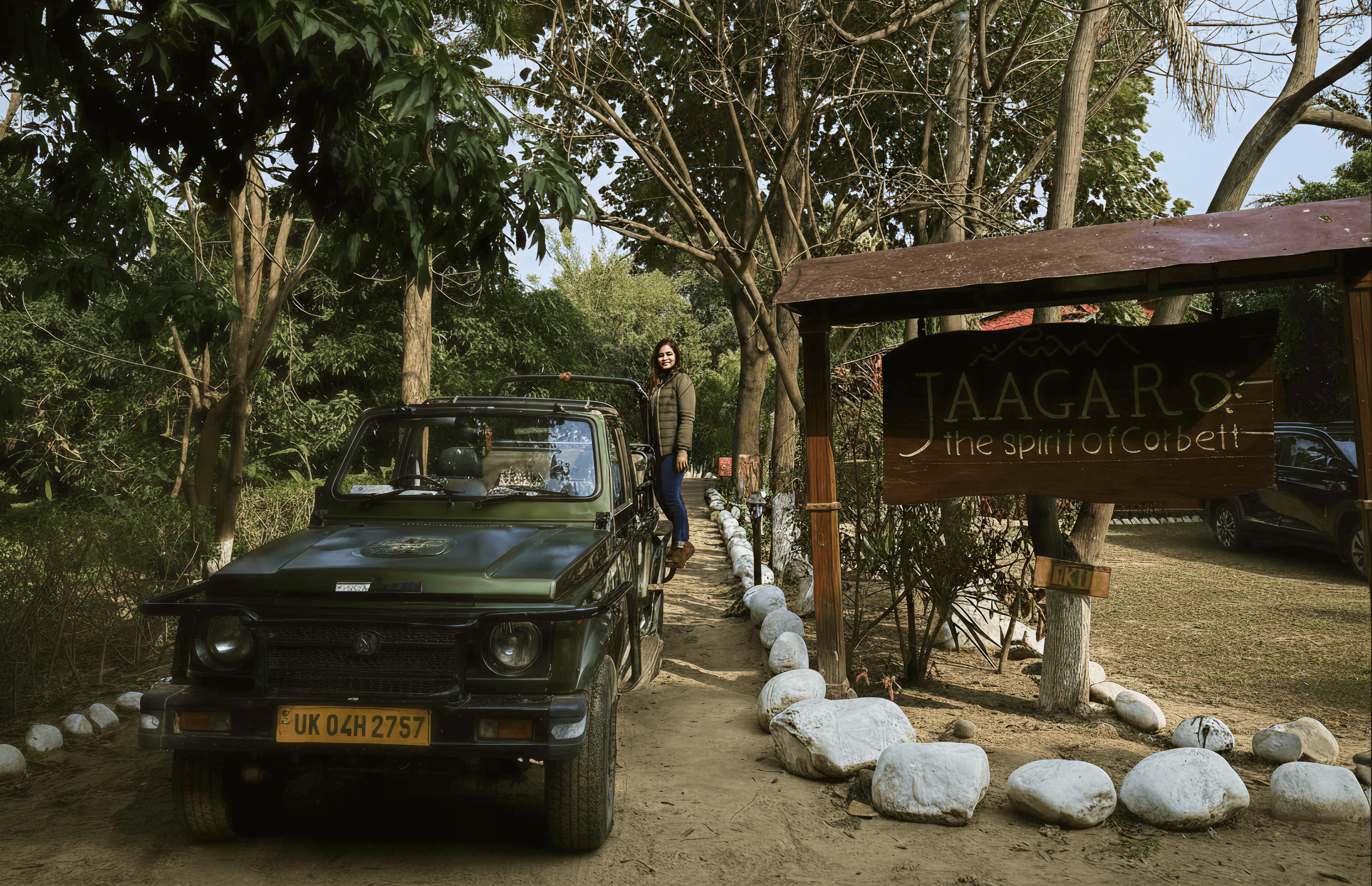 Open safari jeep parked beside the carved Jaagar – The Spirit of Corbett entrance sign