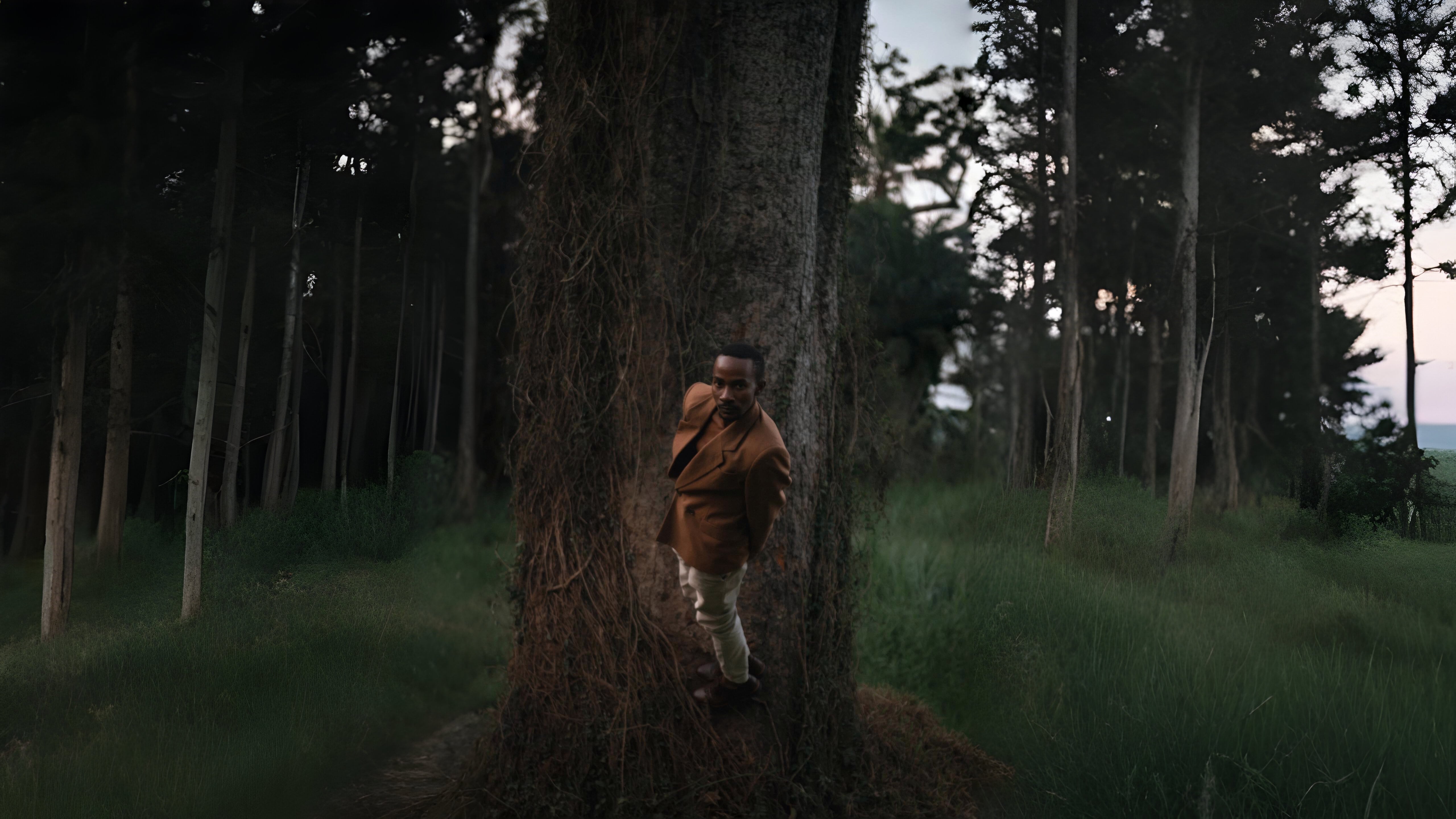 Man posing in front of a tree.