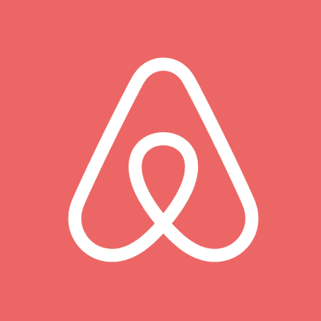 The Airbnb logo, a white "Bélo" symbol, stands out against a vibrant coral background representing connection and.