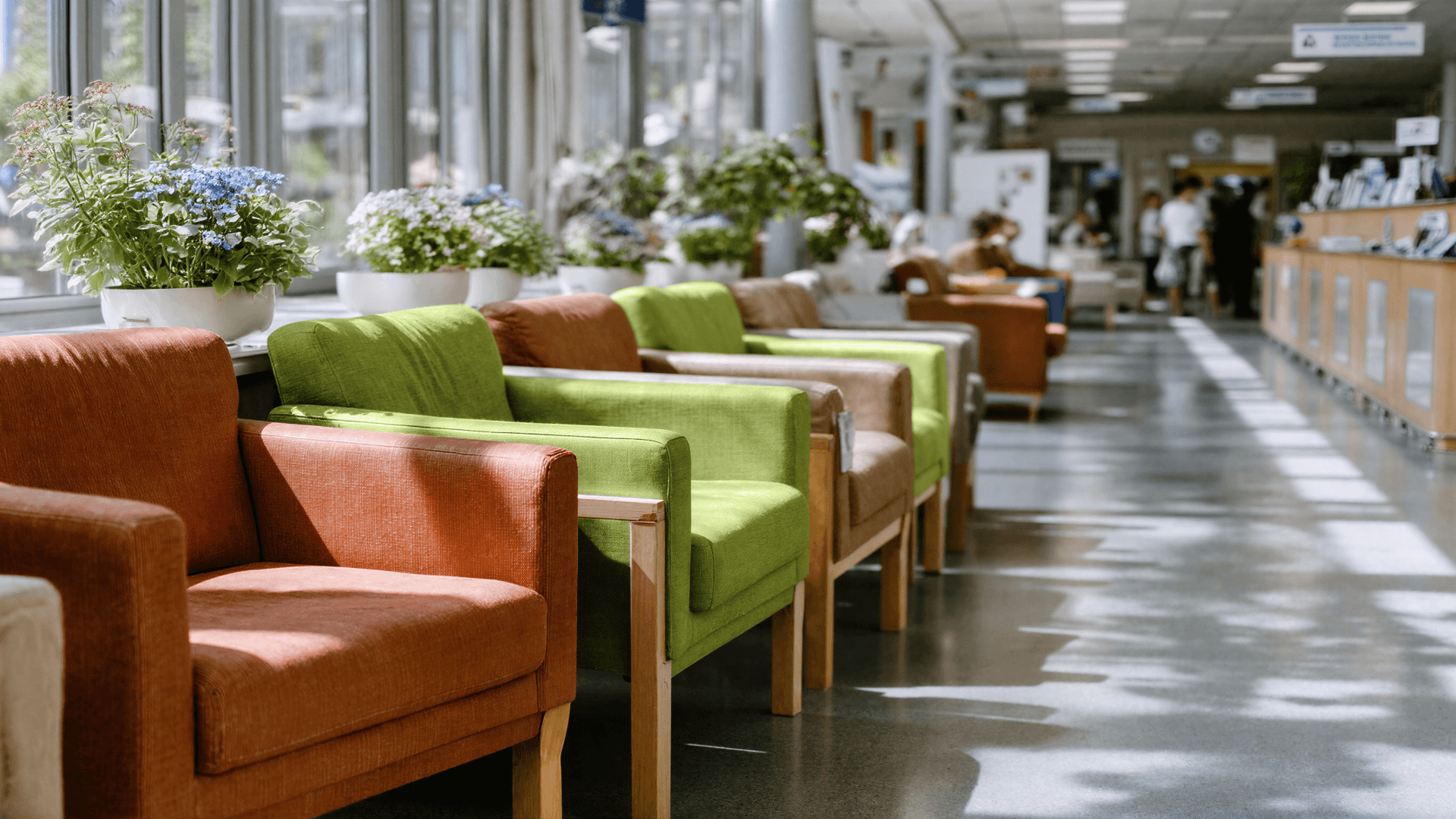 Sala de espera com poltronas coloridas em verde e laranja enfileiradas, representando o ambiente de acolhimento das clínicas que utilizam a Tivita.