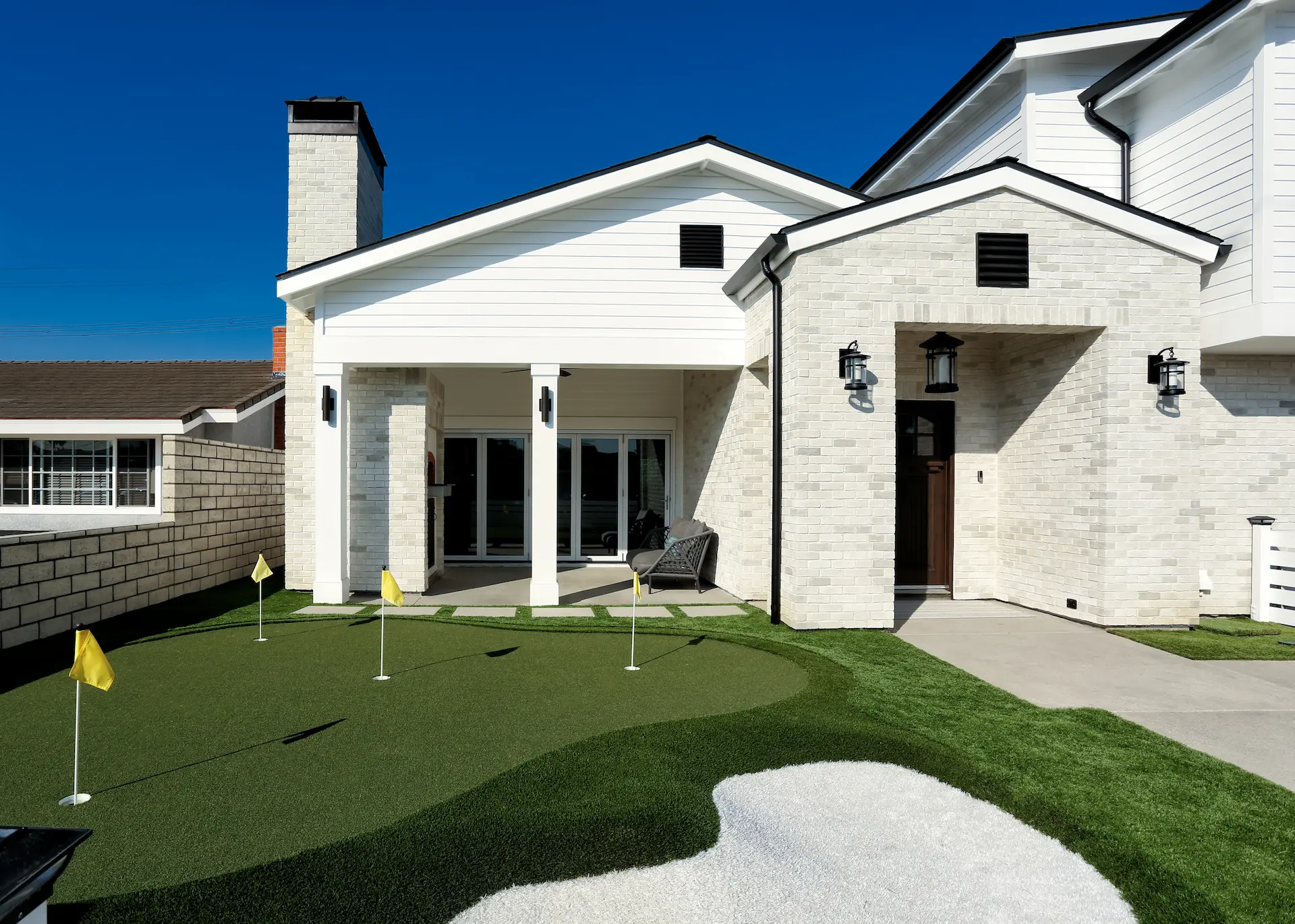 Front view of American Farmhouse home with font yard putting green. Photo by Chris Darnall.