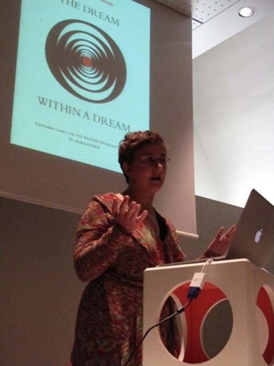 a woman in short hair giving a presentation