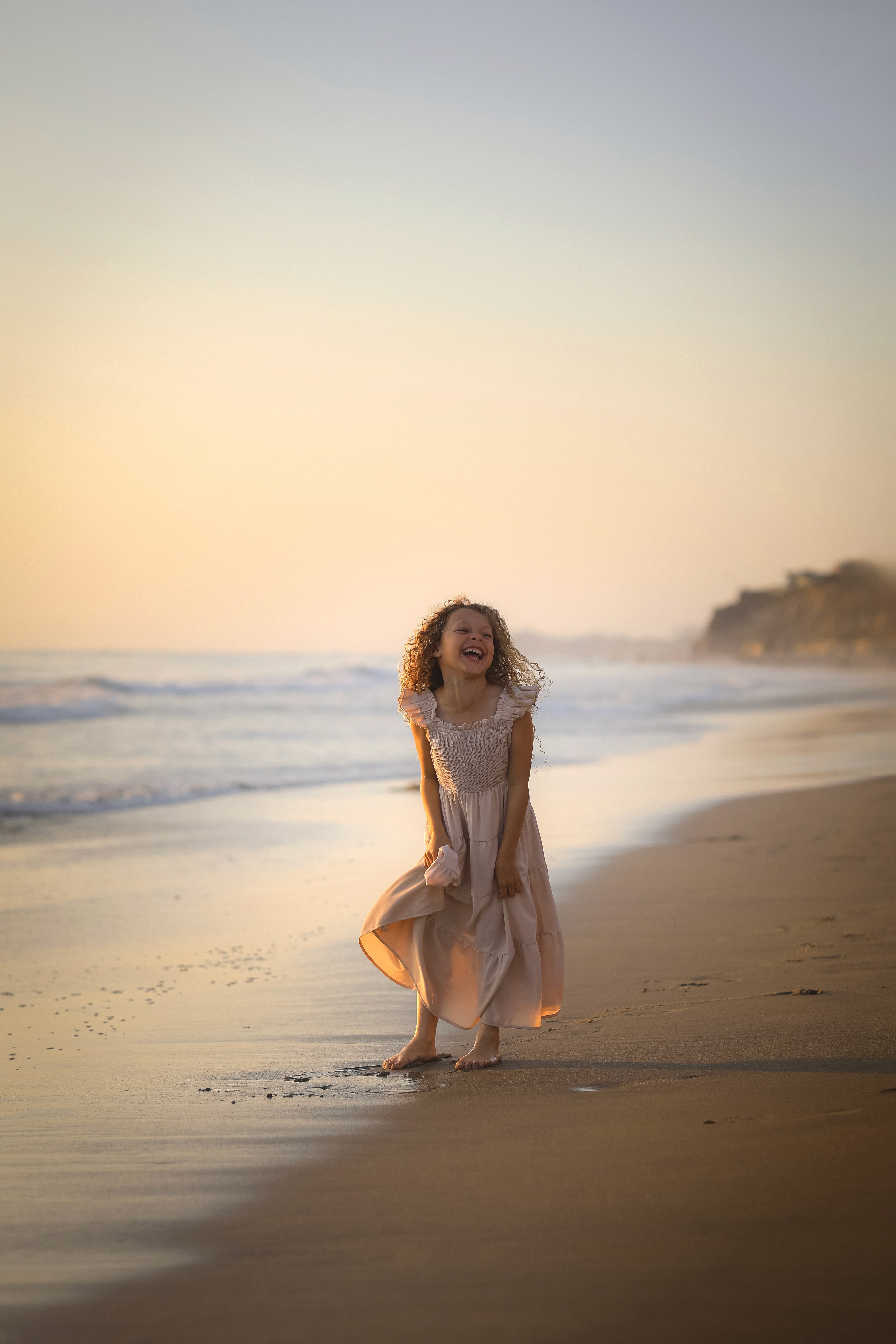 daughter playing by the ocean at sunset in San Diego.