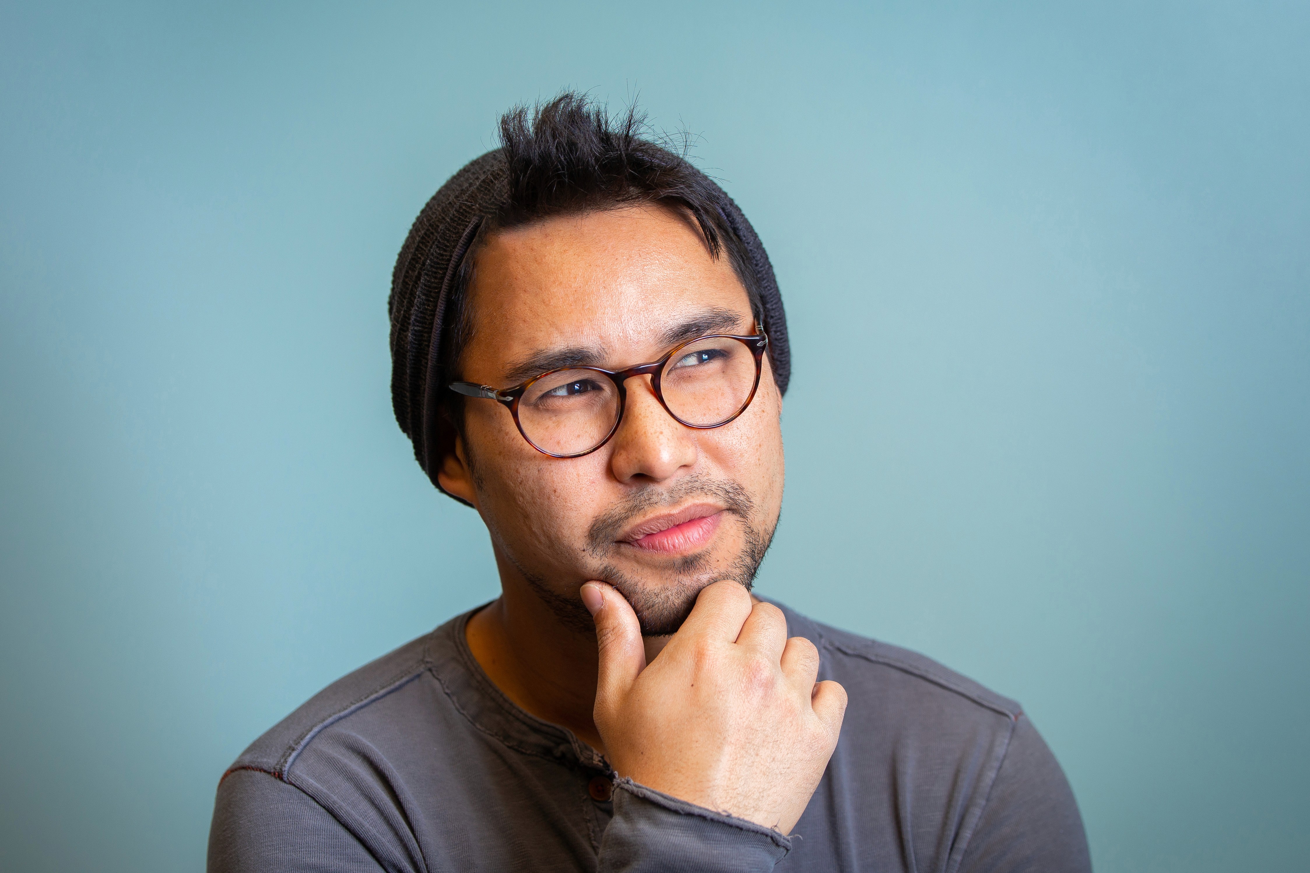 Black and white image of people working at a table with laptops, showing hands gesturing during discussion of digital content displayed on screens, with fabrica® logo in the corner.