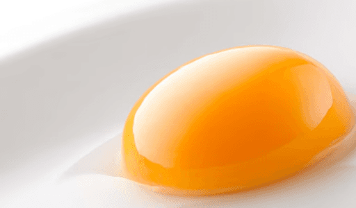 A vibrant, glossy orange egg yolk rests perfectly on a clean white surface, highlighting the freshness of Jinyi Food's.