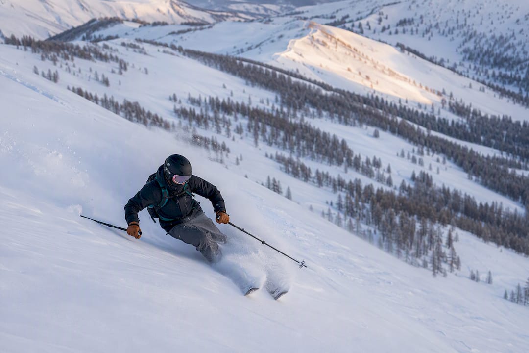 Skier making a turn in deep snow in the Altai backcountry