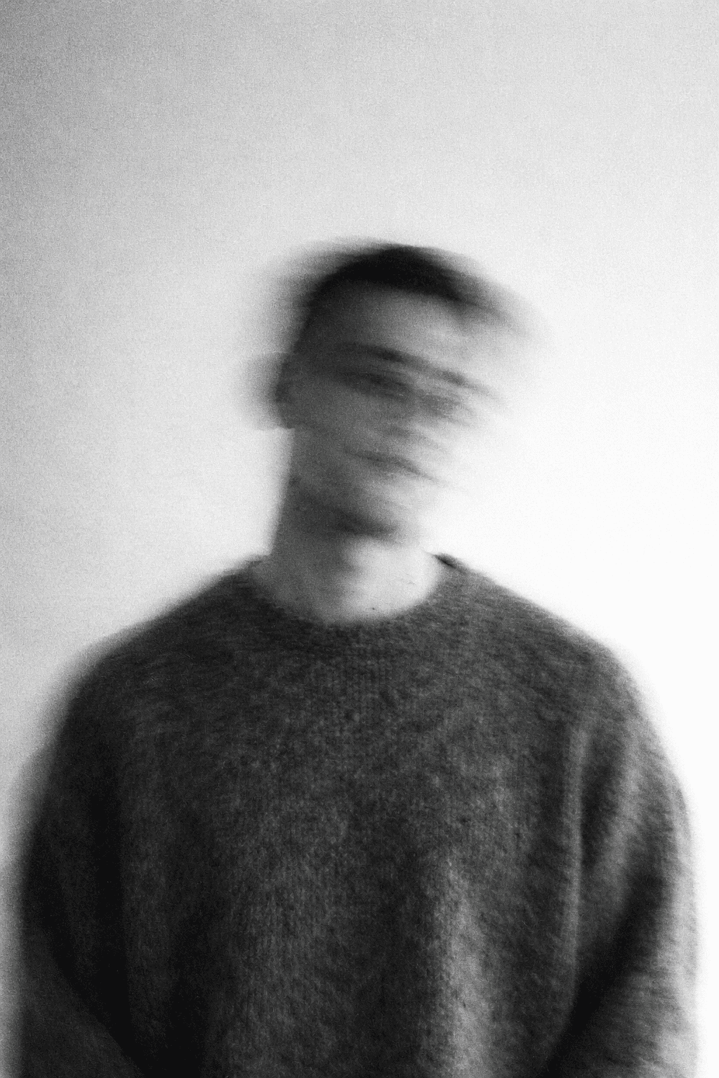 a blurry photo of a person standing in front of a wall