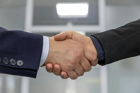 Businessmen shaking hands in a bright office environment