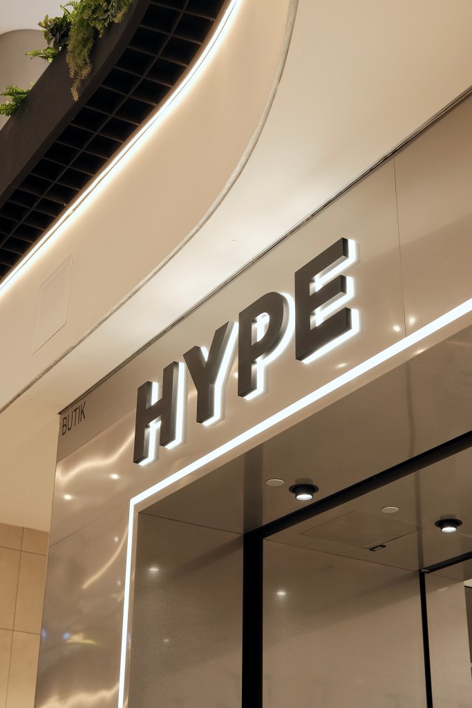 Storefront of a boutique labeled 'HYPE' with modern design and illuminated signage.