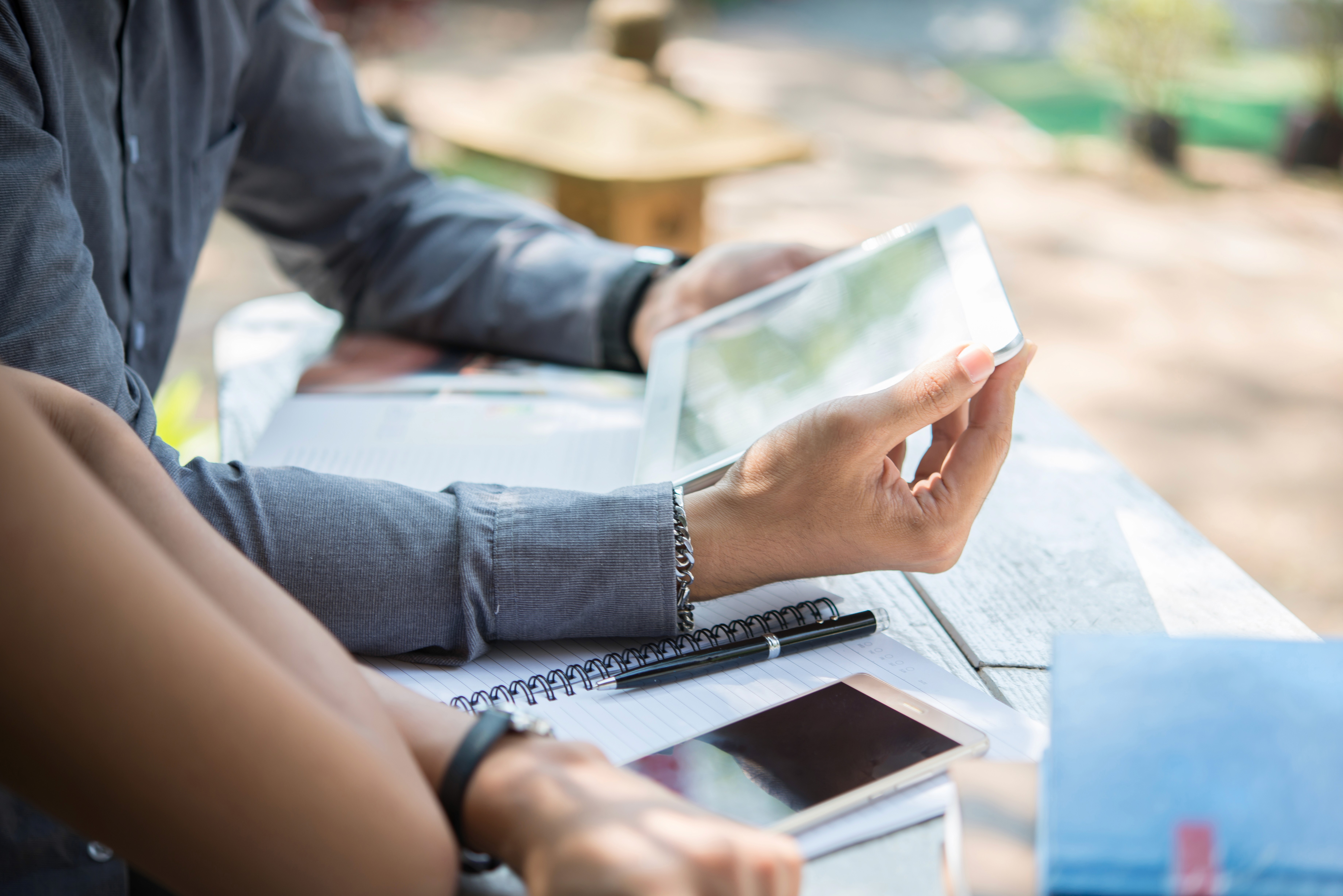 Business professional reviewing documents and data on a mobile device in a work environment, representing modern workflows and digital productivity.