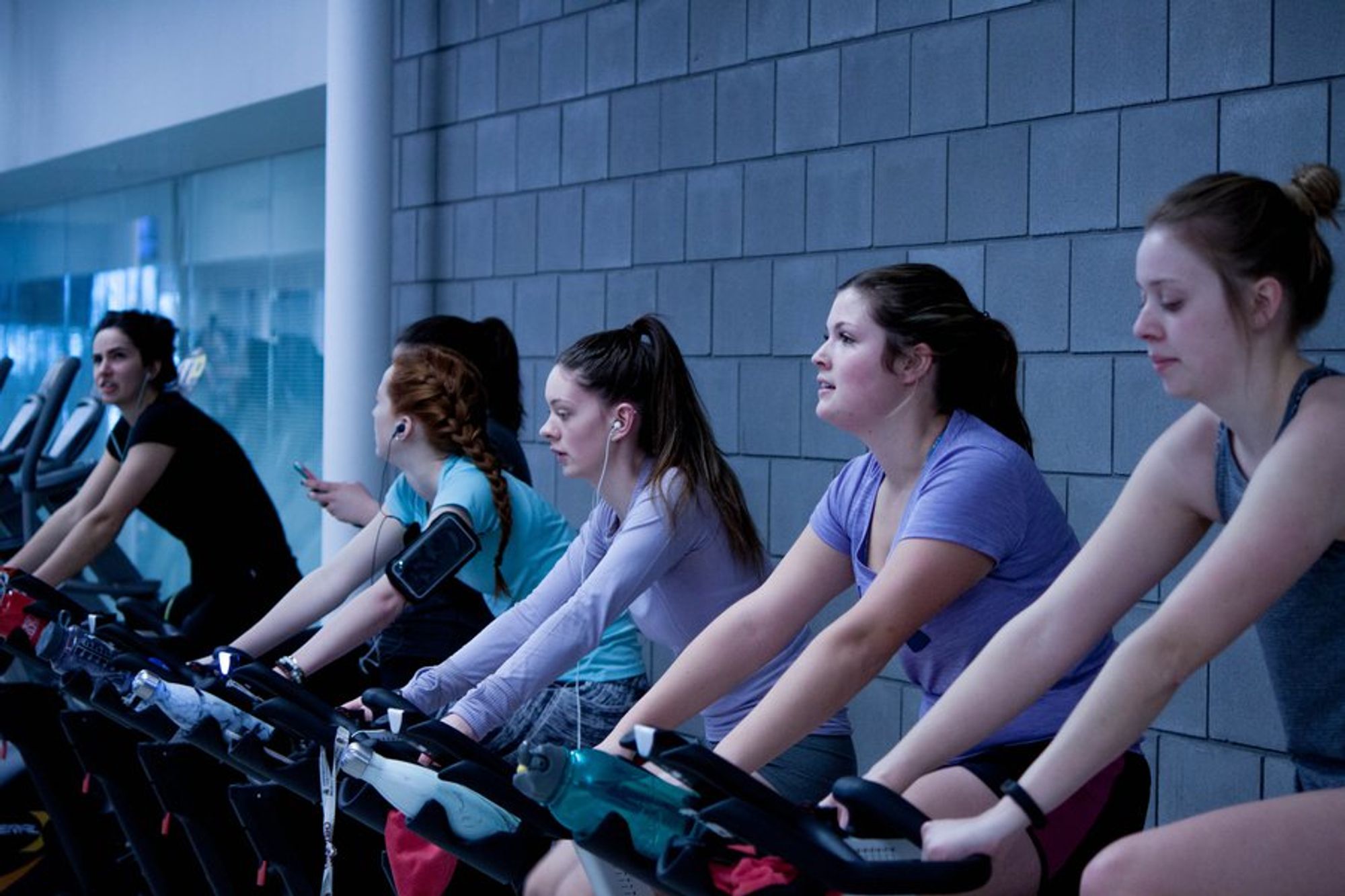 women doing cardio on a stationery bike