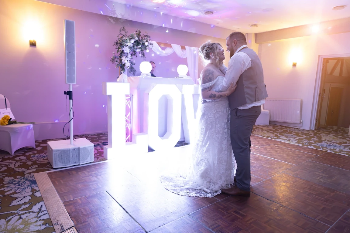 Hannah and Shawn sharing their first dance surrounded by lights at the Charlecote Pheasant Hotel