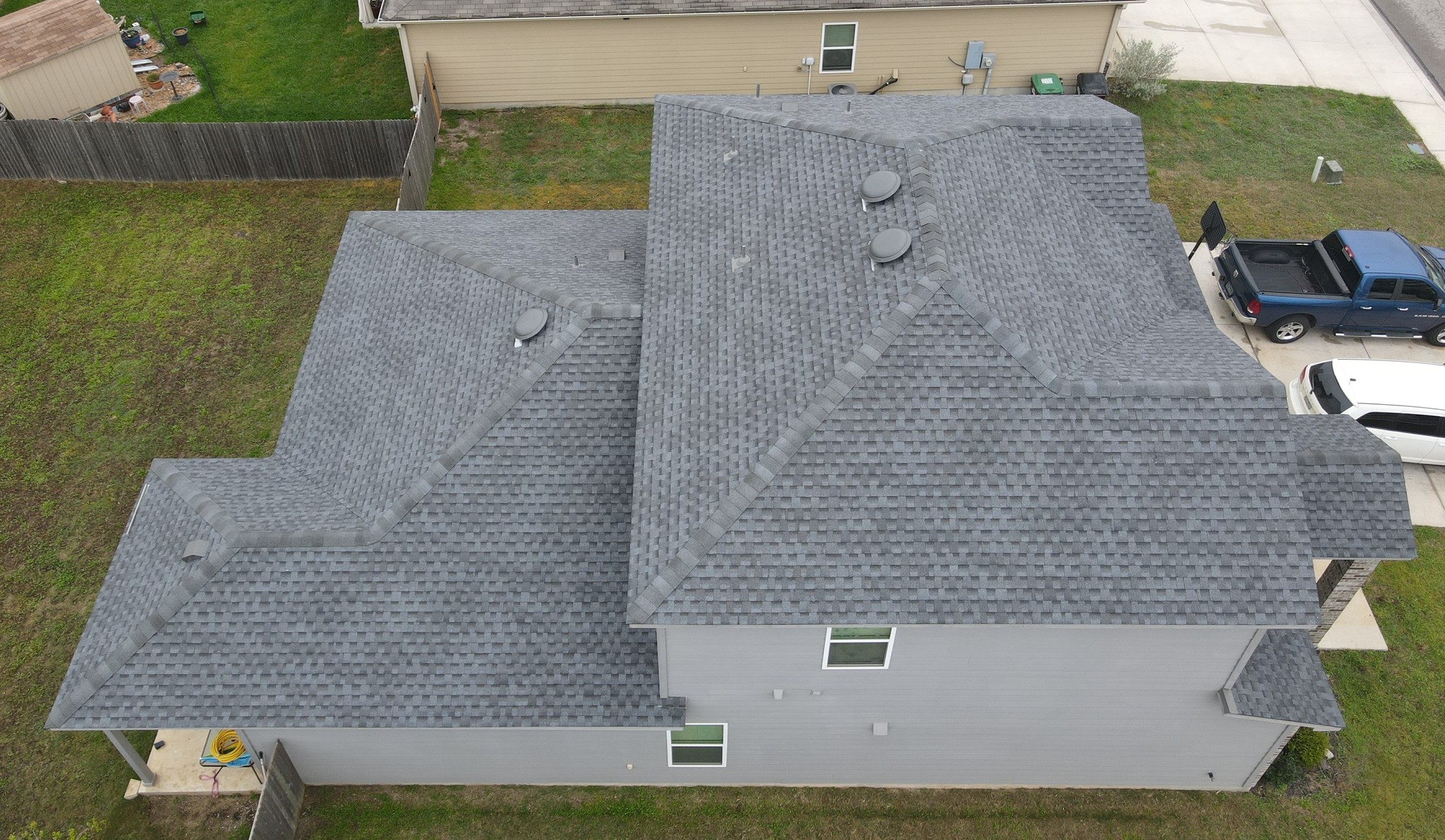 Elegant two-story hip and valley roof featuring GAF Pewter Gray shingles, complete with functional dome vents for enhanced ventilation and a modern, polished look.