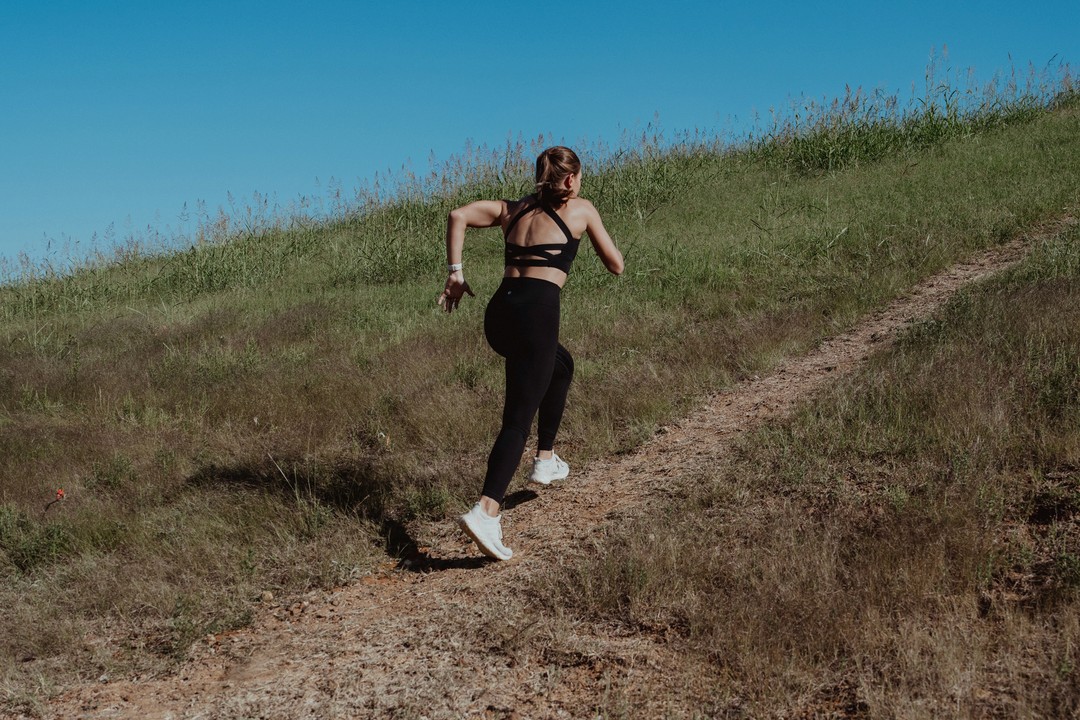 woman running uphill - How to Prevent Stress Fractures From Running