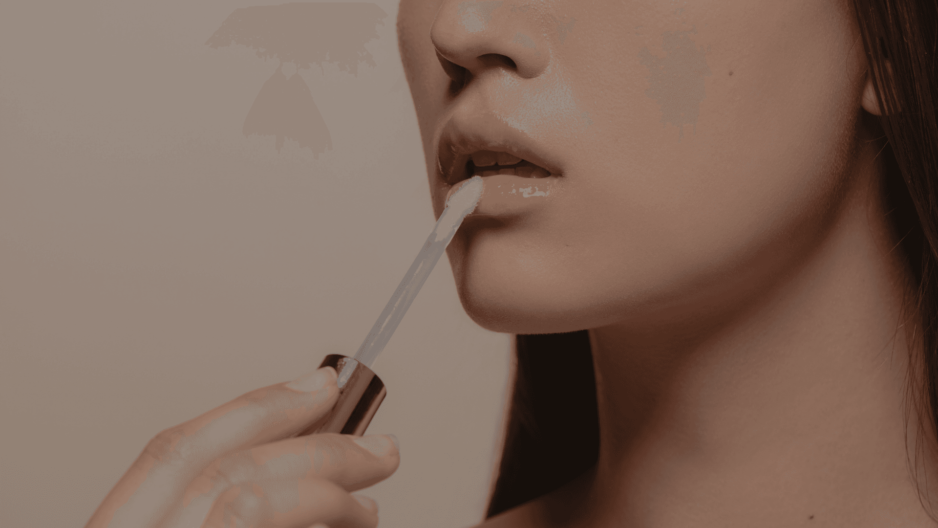 women putting glossy lip balm on her lips