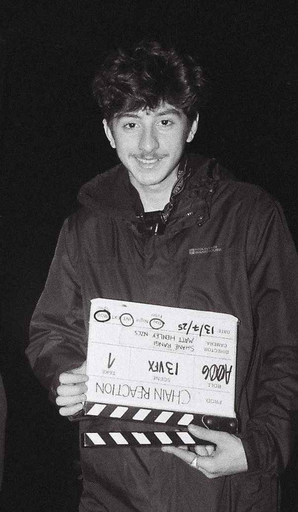 Portrait of a person in a pink sweater against a light background
