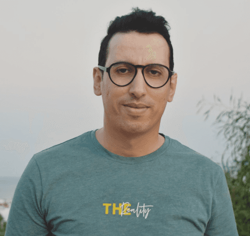 Profile portrait of a man in a white shirt against a light background