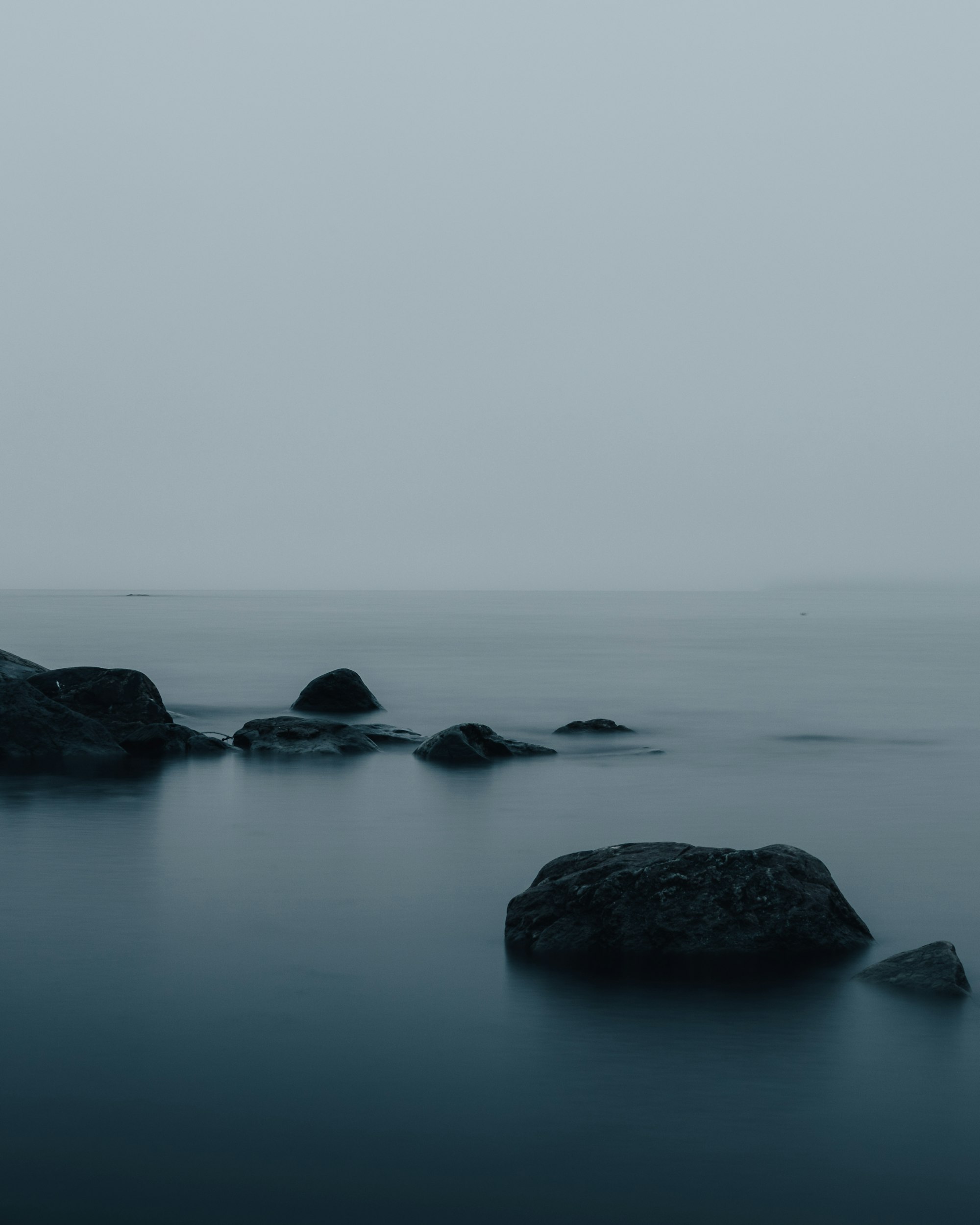 A black and white photo of rocks in the water
