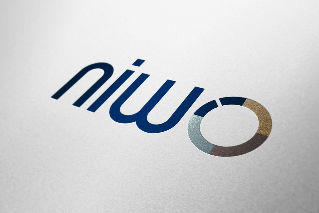 Logo van de NIWO (Nationale en Internationale Wegvervoer Organisatie) gedrukt op wit papier, met een grafisch cirkelelement in meerdere kleuren.