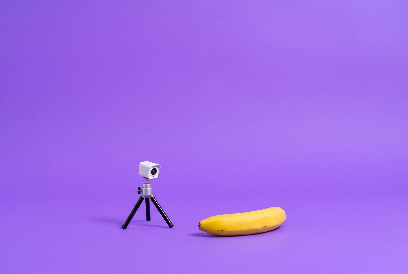 A tiny security camera on a tripod aimed at a banana, a playful QUITTR vs Covenant Eyes comparison
