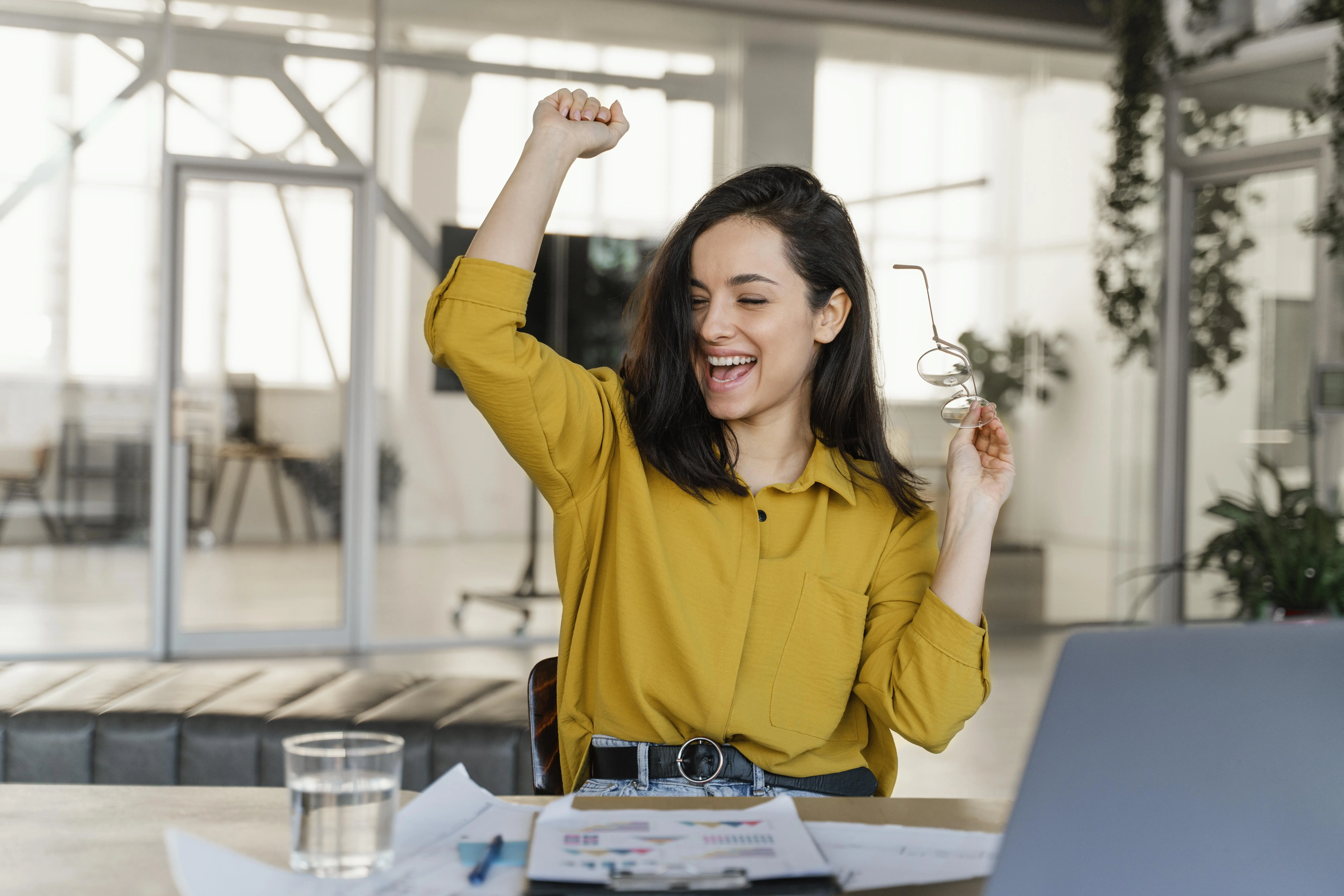 Mulher comemorando a promoção no trabalho. 