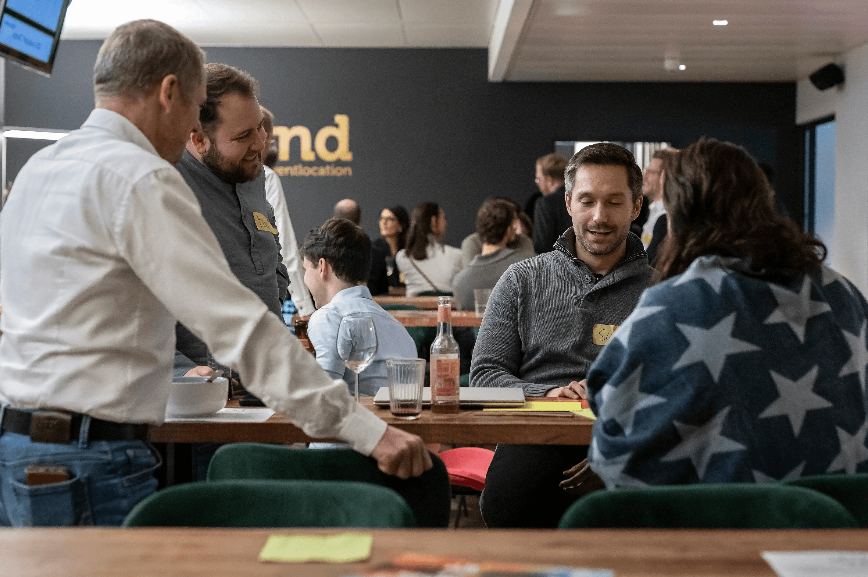 People crossing a busy street with cars and buildings.