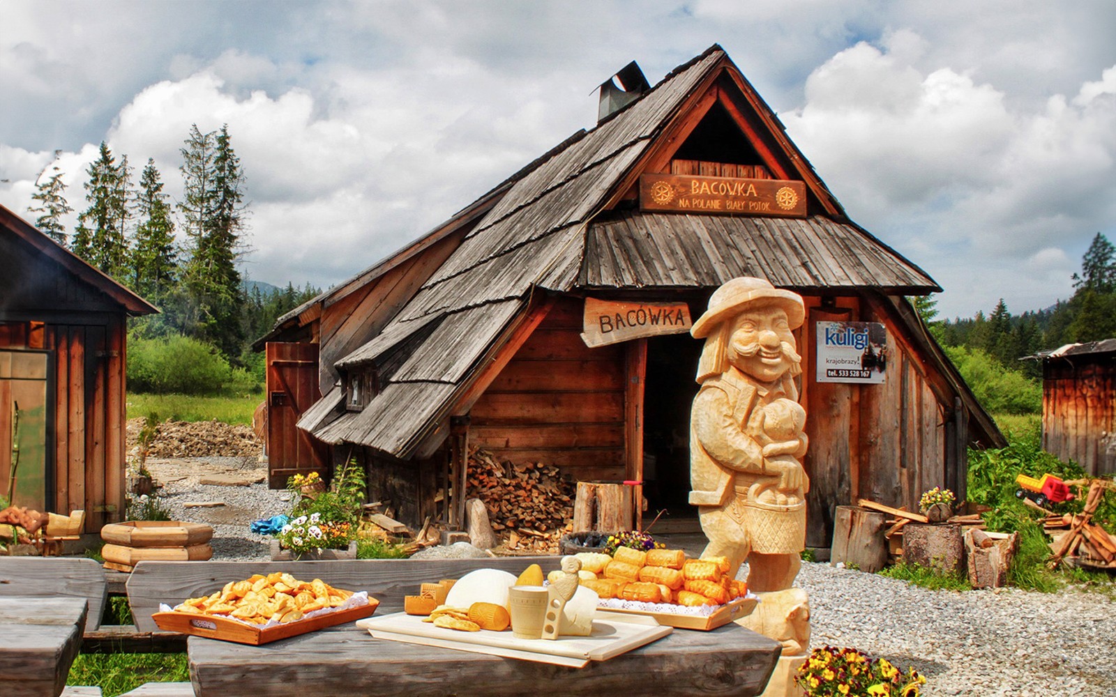 Traditional wooden hut in Zakopane with cheese display and carved figure.