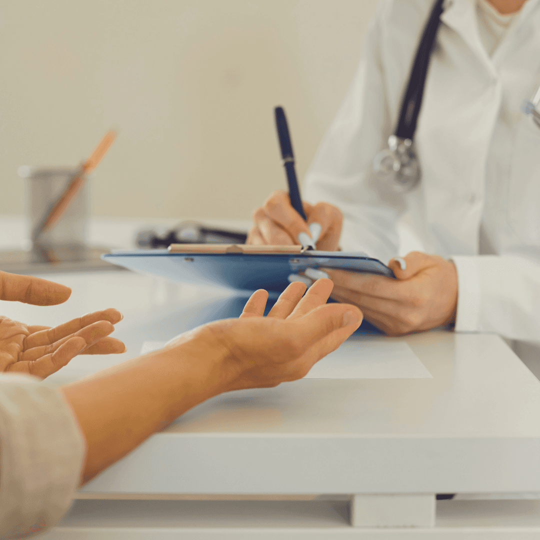 Doctor taking notes while talking to a female patient
