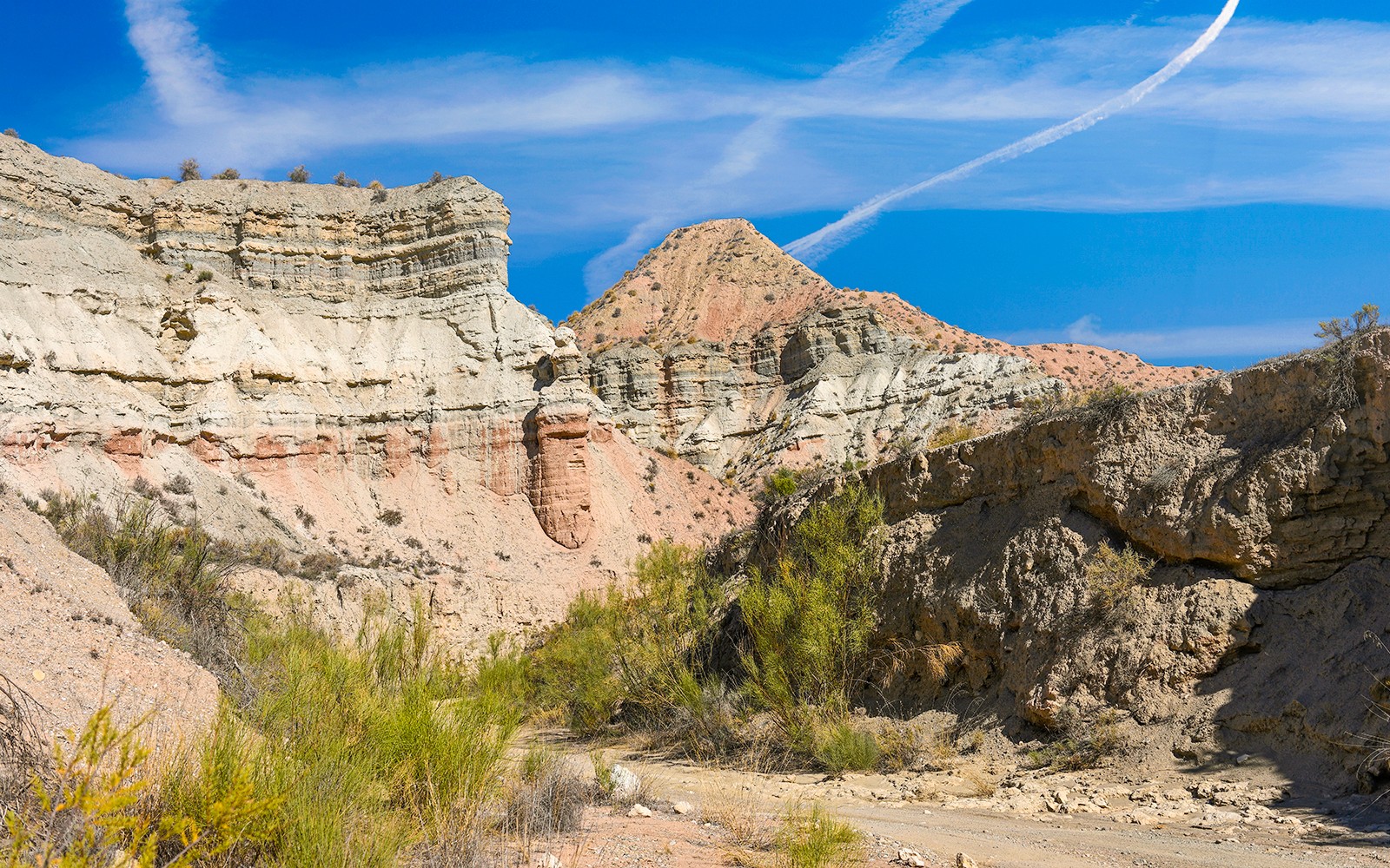 格拉纳达地质公园沙漠景观，层层叠叠的岩石地层在晴朗的蓝天下展现。