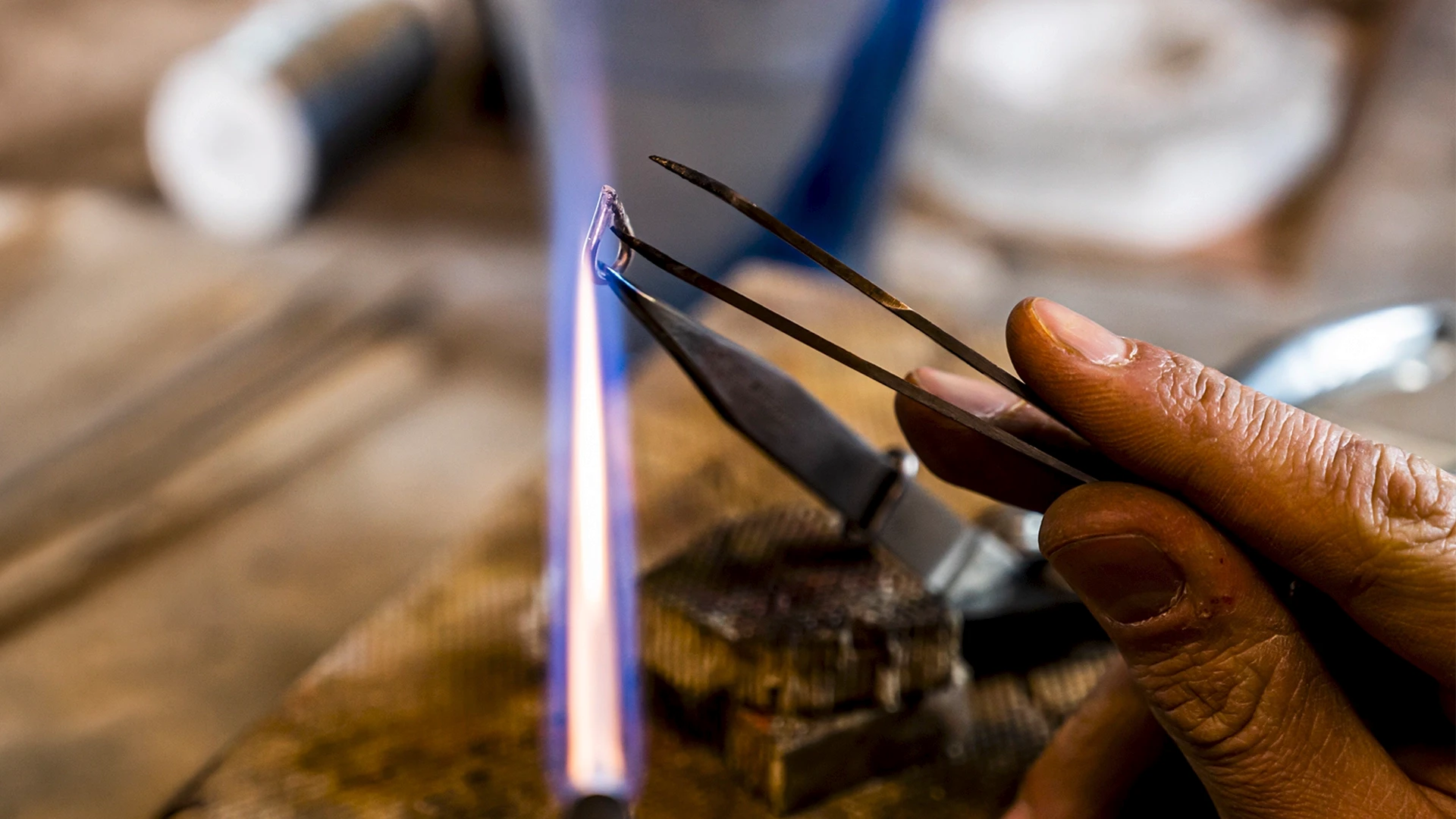 Goldsmith soldering metalwork at the jeweller's bench for a 12 creation