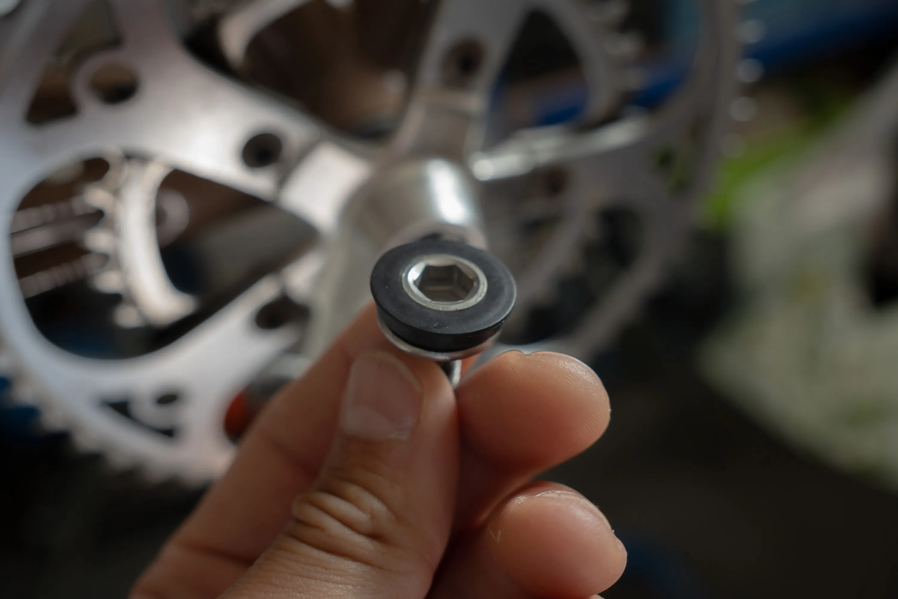 A close up of a person working on a bike crankset