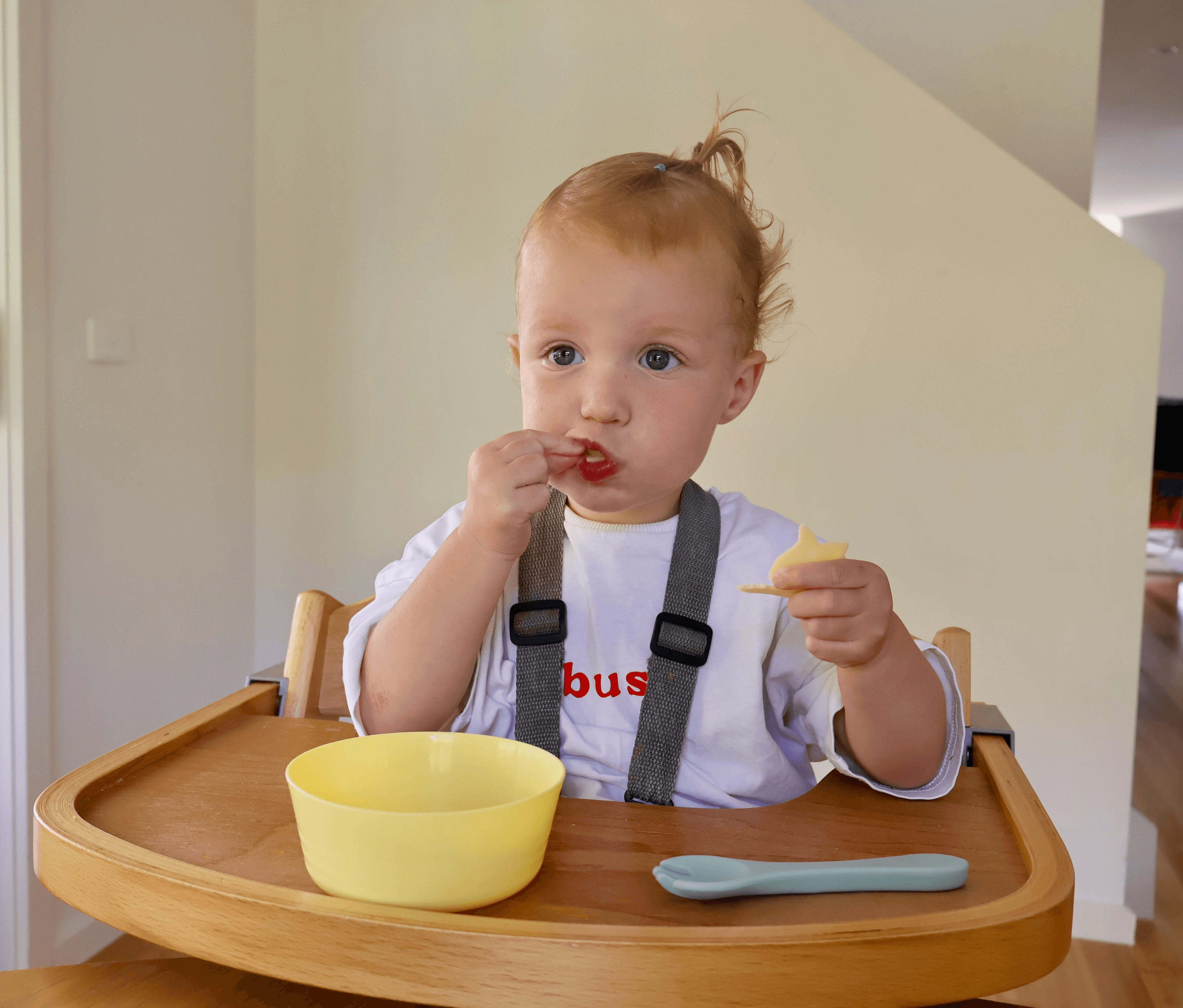 Female toddler eating cheese during mealtime.