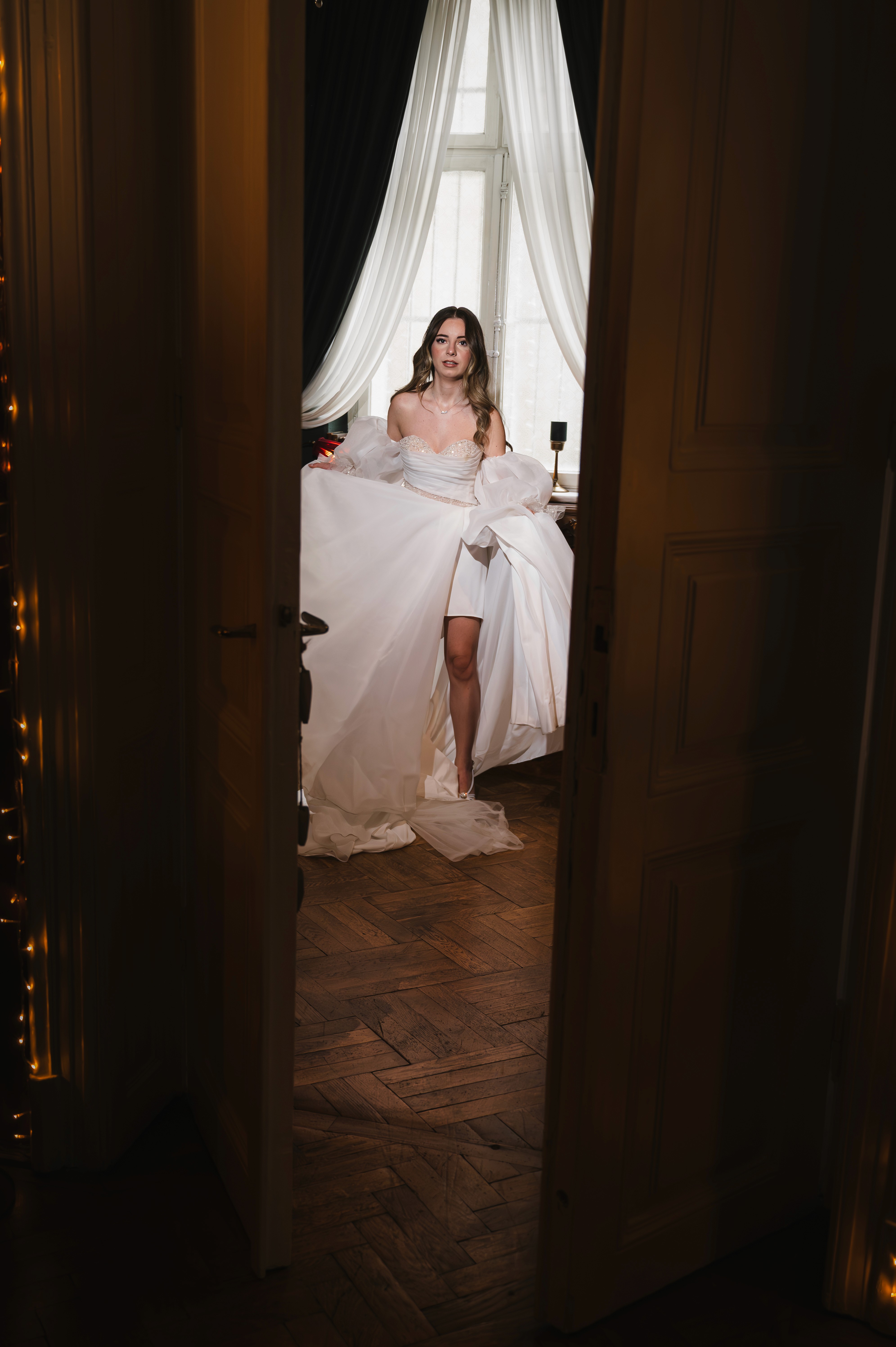 Mireasă zâmbind peste umăr, rochie albă cu spatele gol, lumină caldă, fotografie spontană nuntă