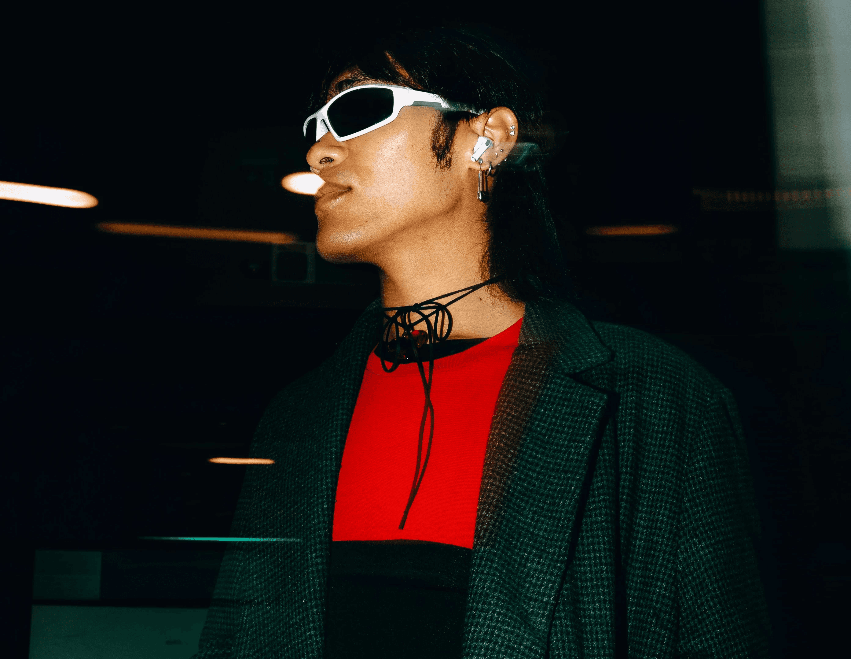 A woman in a black coat and sunglasses holding a purse