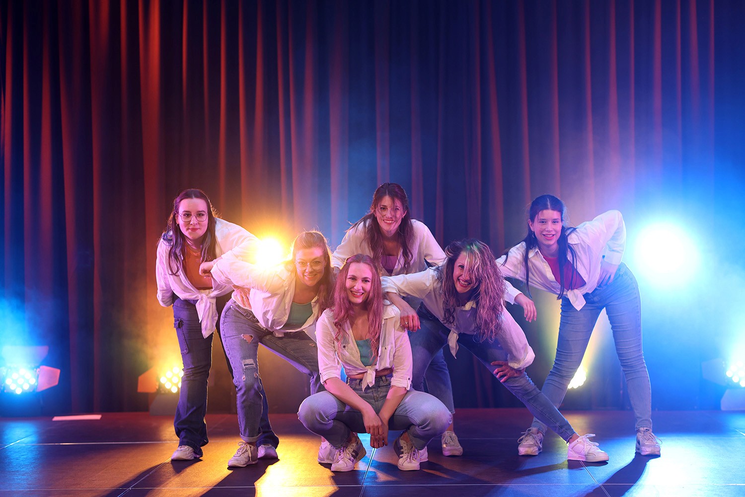 Eine Poltergruppe von sechs Personen, die auf der Bühne steht.