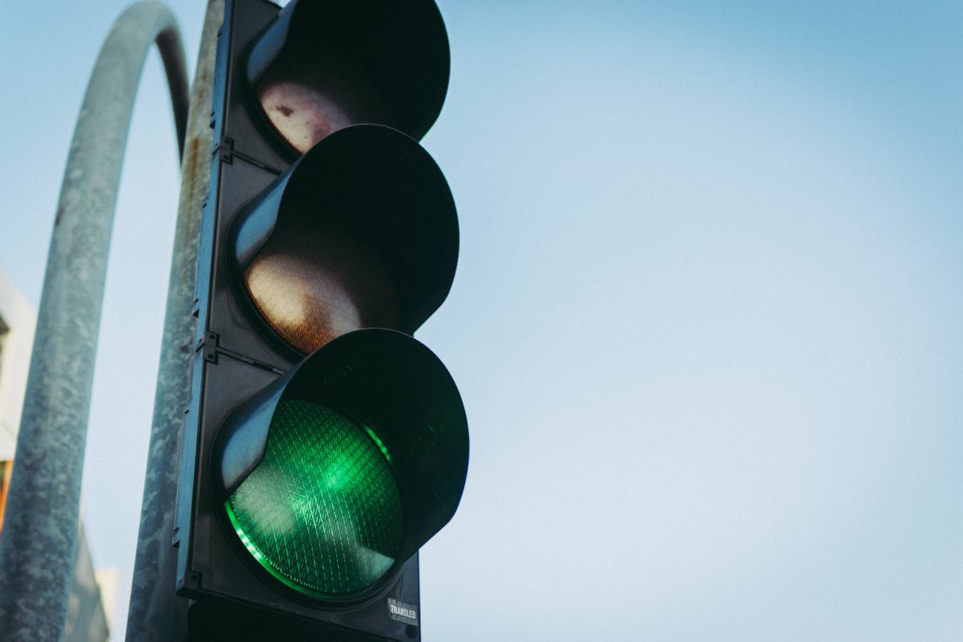 Green traffic light against a clear blue sky