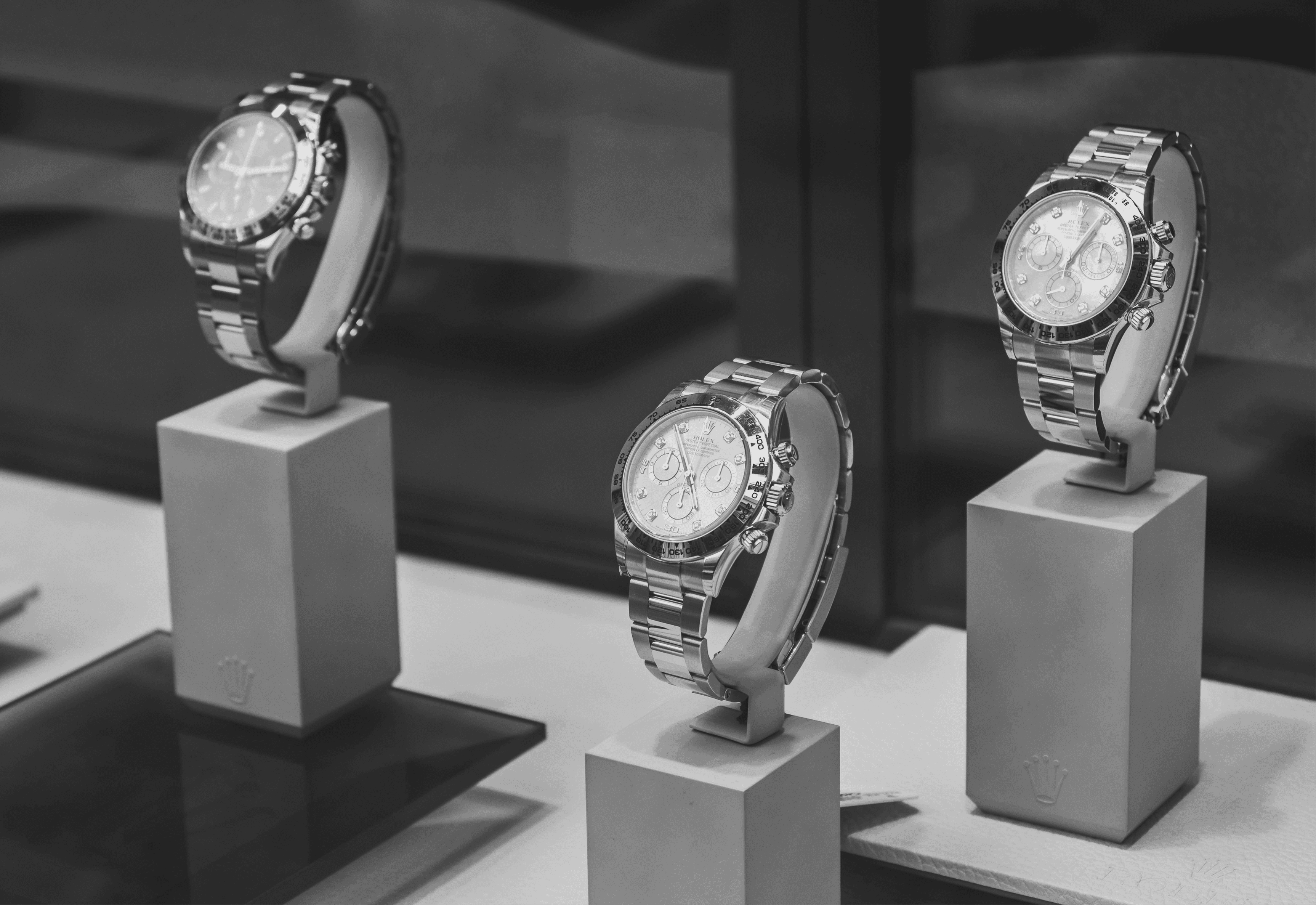 Smiling man wearing a turquoise t-shirt and white overshirt, confidently adjusting his collar against a teal-blue studio backdrop.